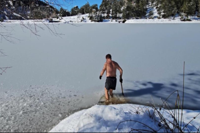 Uludağ'ın buz tutan göllerine girerek soğuk suyun keyfini çıkarıyor